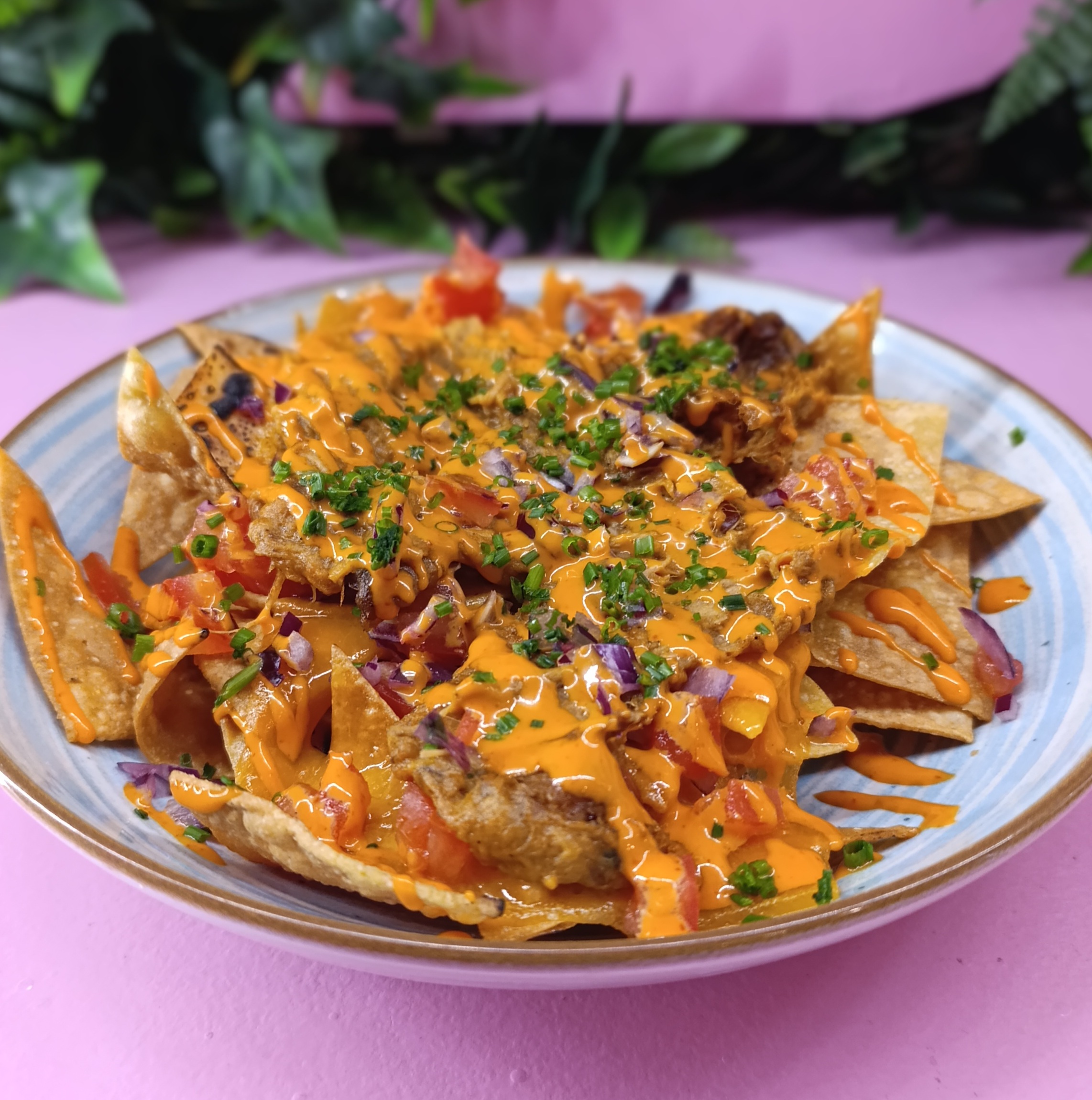 Nachos con queso, cochinita pibil y guacamole